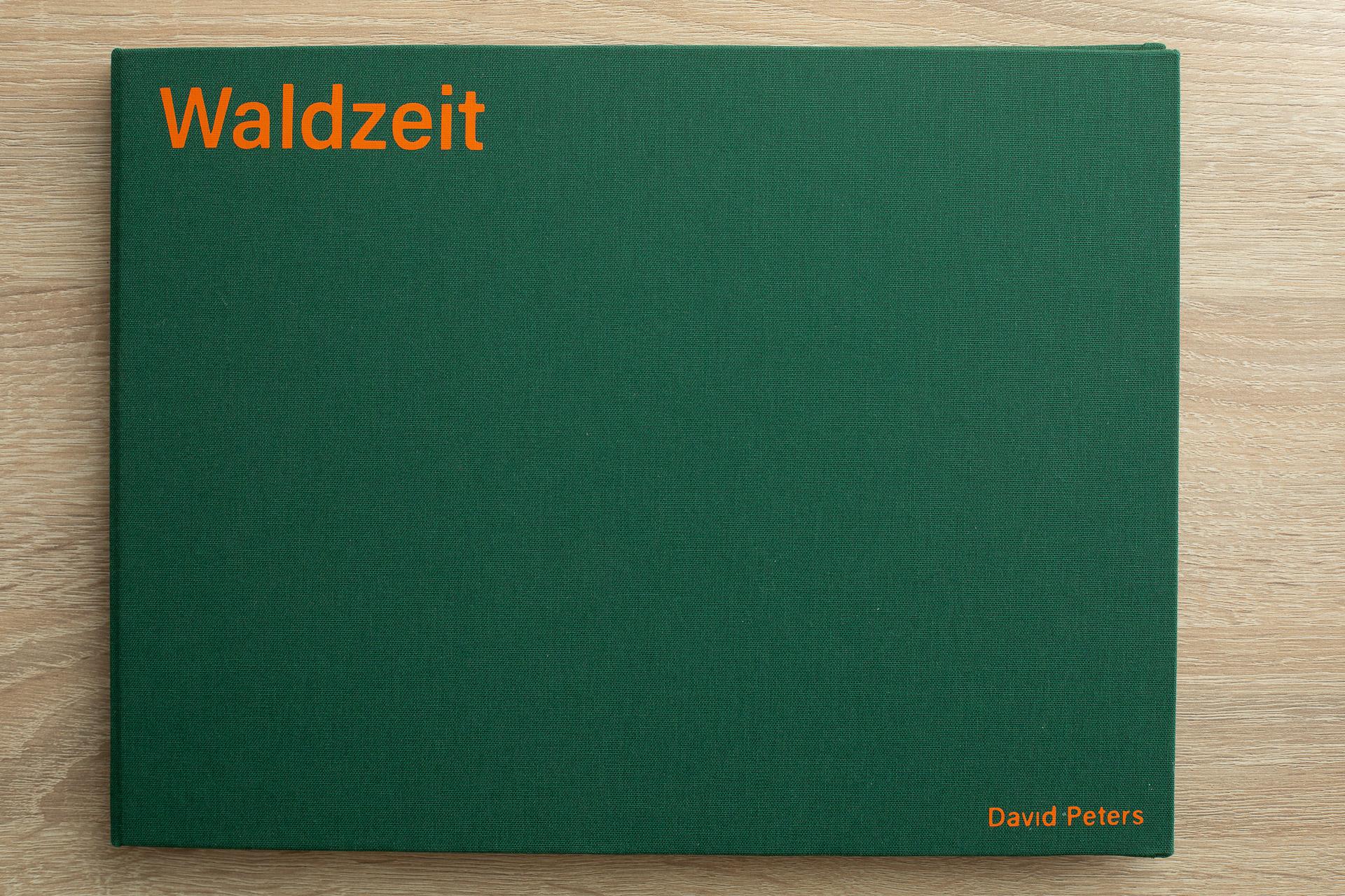 In grünem Leinen eingeschlagenes Buch, mit orangenem Schriftzug oben lins "Waldzeit" rechts unten der Name des Autos "David Peters"